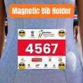 A person wearing a blue patterned athletic bib shirt with a printed race bib pinned to the front. An orange banner at the top reads 'Magnetic Bib Holder.